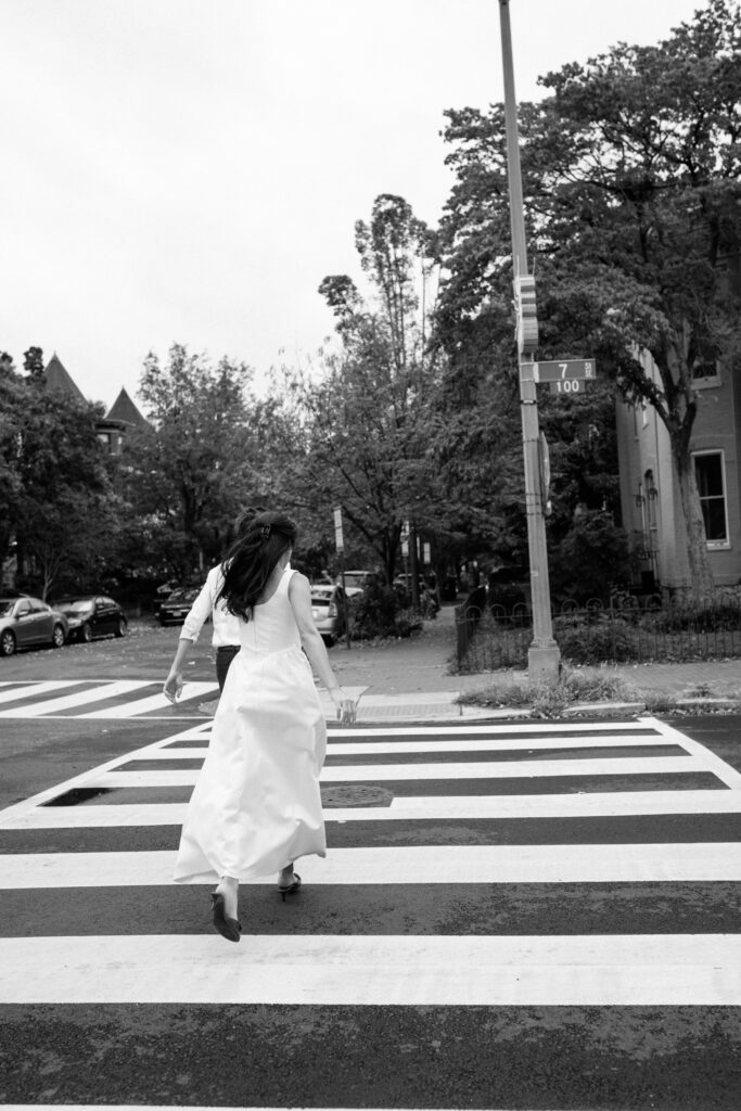 Couple walking across crosswalk in Capitol Hill during Washington DC engagement photography session