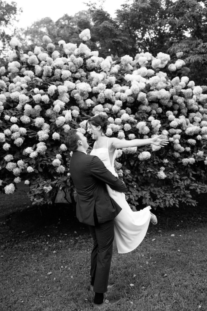 Playful moment of the couple celebrating together outdoors during the reception at Appleford Estate.