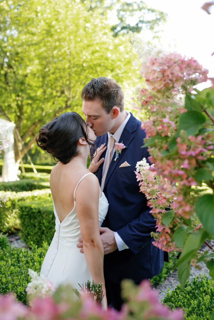 Golden hour portrait of the couple in the iconic boxwood gardens at Appleford Estate with warm sunlight filtering through the trees.