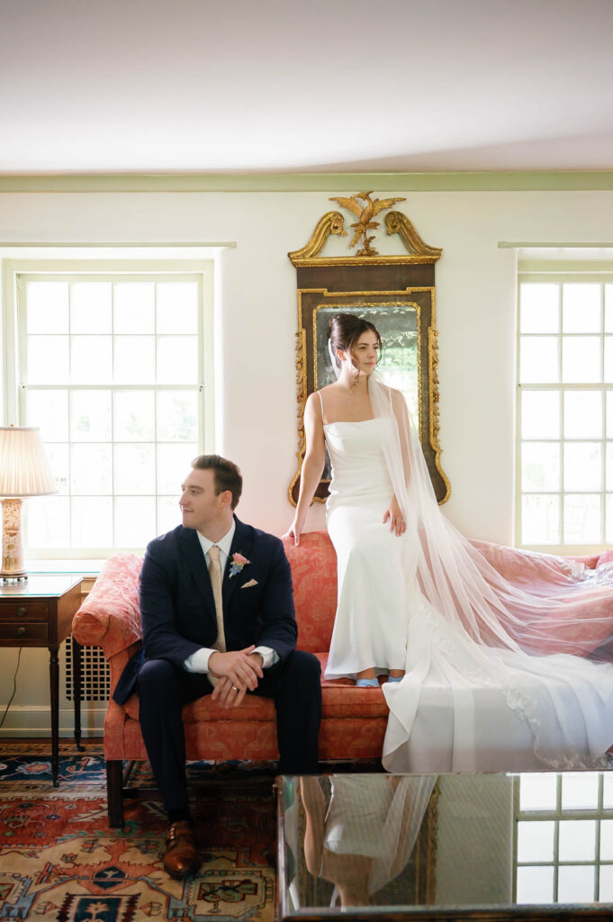 Bride and groom posing together in the elegant sitting room of the Appleford Estate manor surrounded by classic architecture and natural window light.